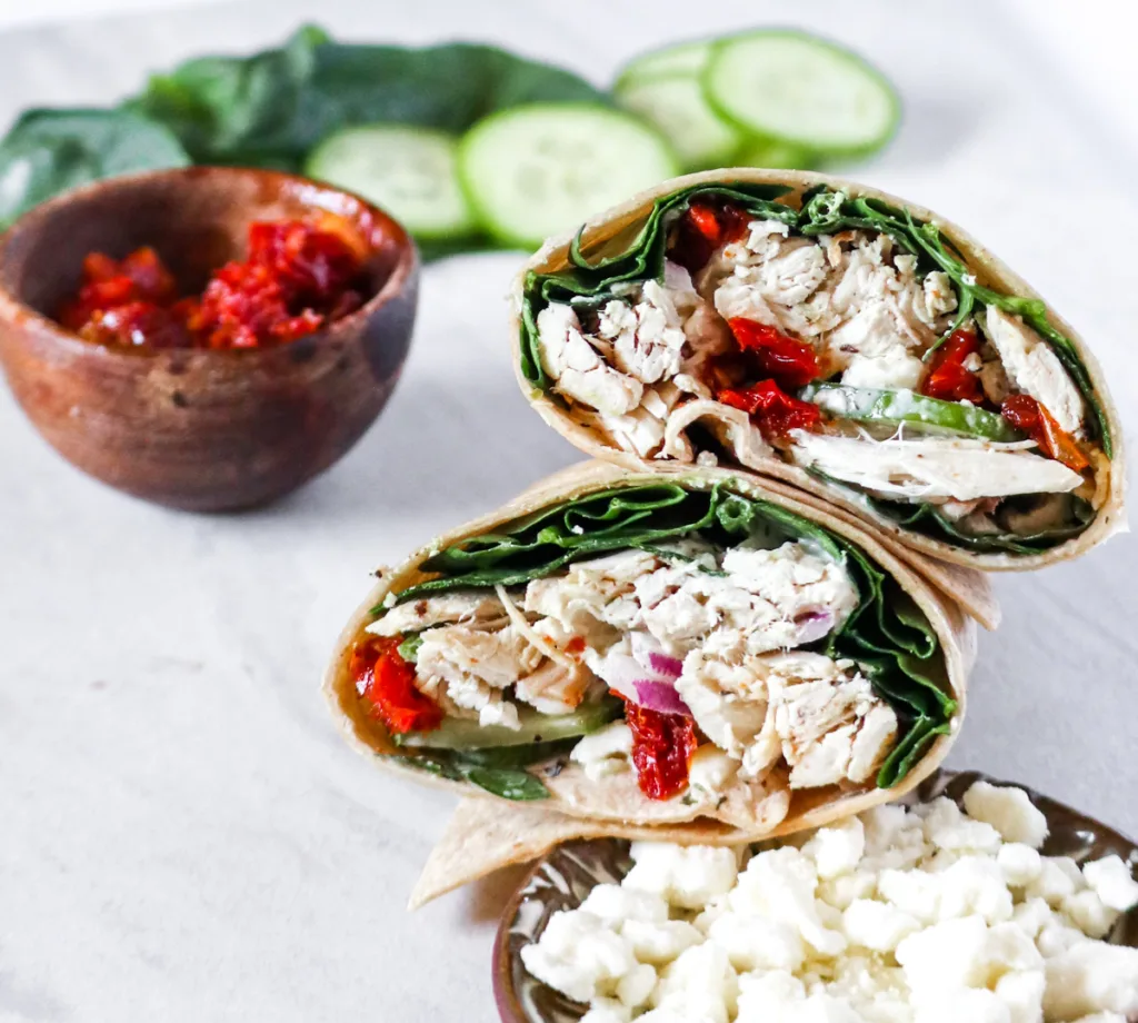 chicken wrap with spinach, cucumbers, onion, sun-dried tomatoes, tzatziki, and feta.