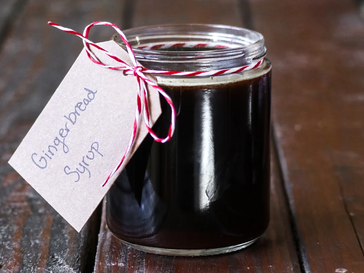 gingerbread simple syrup in a labeled jar with a red and white ribbon